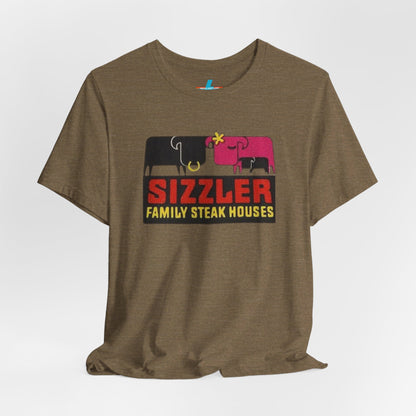 The "Sizzler Family Steakhouses - Retro 1981 Logo - Unisex Jersey Short Sleeve Tee" by Printify is a gray t-shirt showcasing a retro-style graphic with two black and pink cows, a cactus, and the text "Sizzler Family Steak Houses" in vibrant red and yellow. Ideal for any retro enthusiast, this design evokes nostalgia reminiscent of vintage restaurant logos from 1981.