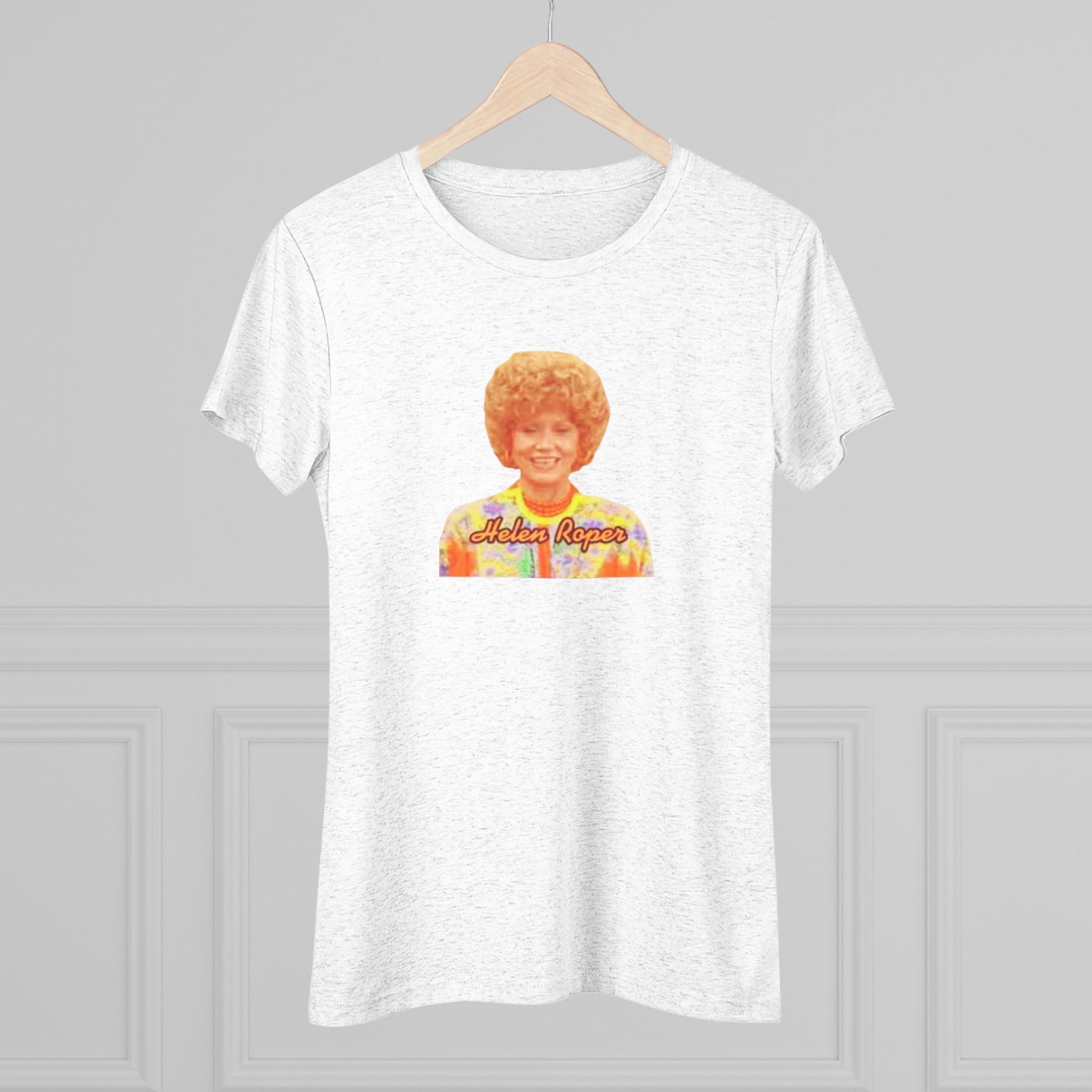 A Women's Triblend Tee by Printify, titled "Helen Roper - Three's Company," features a red design with an illustration of a smiling person with curly hair and colorful clothing. Below the illustration, the text "Helen Roper" is written in a bold, retro font, capturing the essence of vintage TV humor.