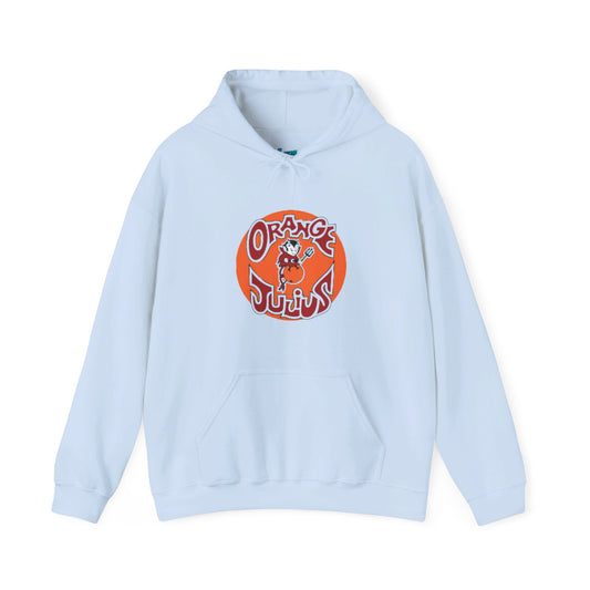 A light blue Orange Julius - Retro 1980s Hoodie by Printify, featuring a front pocket and hood. This nostalgic piece of clothing showcases a large, circular logo in orange and red at the center, depicting an illustrated character from 1980s mall culture.